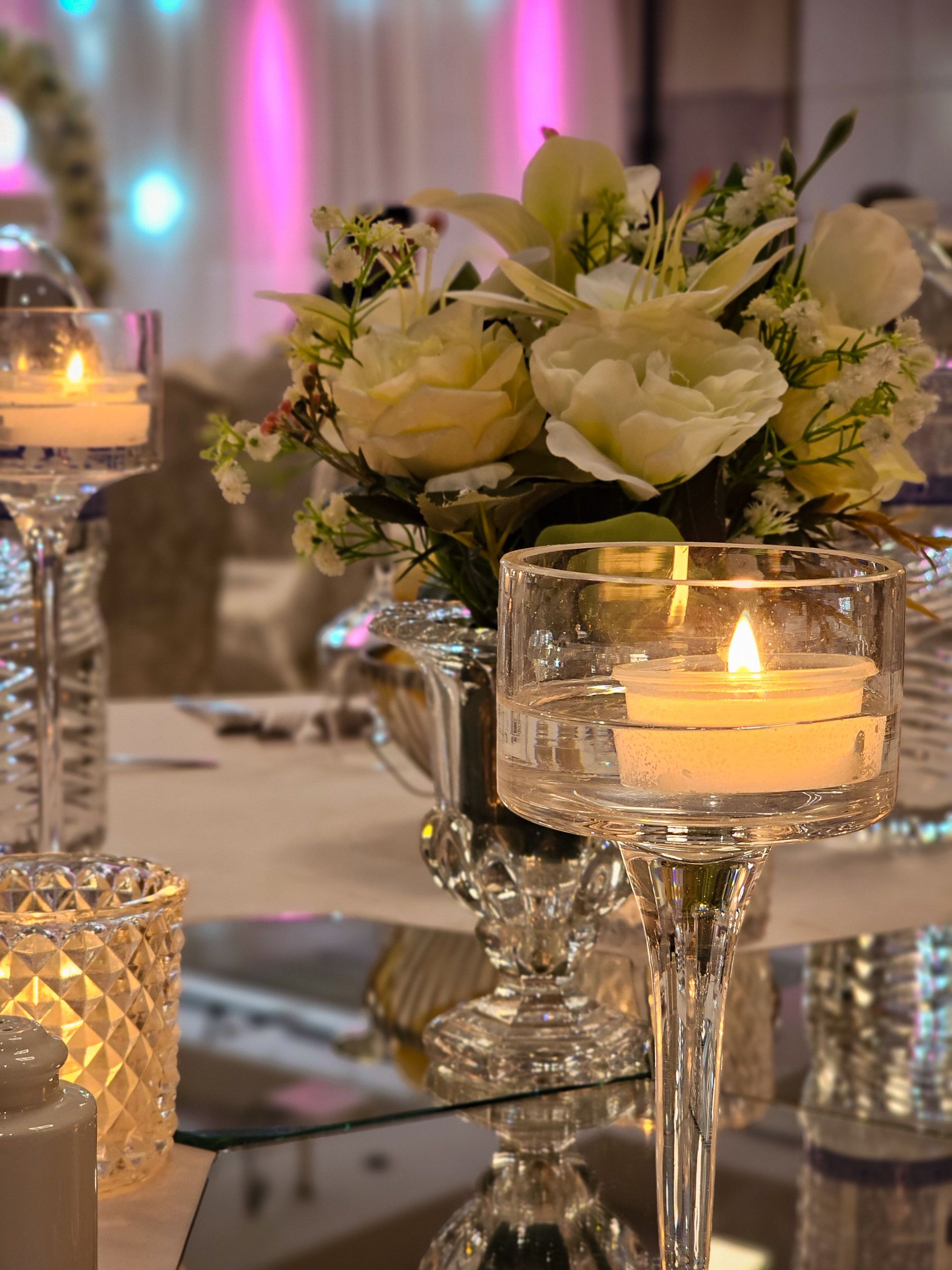 Beautiful floral centerpiece with candles on a wedding table, creating a warm ambiance.